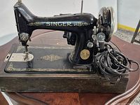 Left side view of Singer sewing machine on base showing decals, motor and power cord