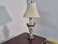 Full view of table lamp showing porcelain base, handles, shade