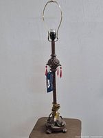 Full view of bronze-tone metal lamp base with harp and socket