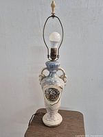 Full view of porcelain table lamp with finial and bulb
