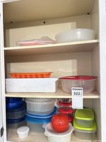 Cabinet shelves holding all plastic containers, Pyrex bowls and ice cube tray
