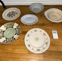 Six assorted plates, platter and bowls laid out on floor