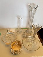 Group shot displaying all glass vases, bowls, holder, votive, and sphere