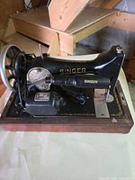 Side view of Singer sewing machine on wood base with motor and decals visible