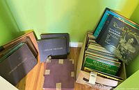 Wide shot of stacked LP binders and box of records in corner