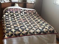 Quilt spread on bed showing full design and size