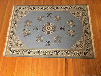 Full view of blue and beige wool rug on hardwood floor
