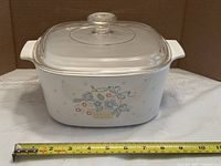 Front view showing floral basket design and tape measure for size