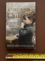 Front cover showing title and author with measuring tape for scale