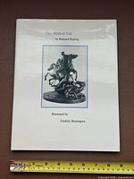 Front view of book with dust jacket and ruler for scale