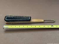 Brush beside tape measure showing 13 in length