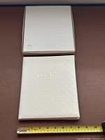 book and lid of original box displayed with tape measure for scale