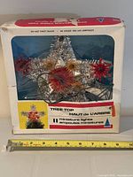 Box front showing product name, star topper visible through window