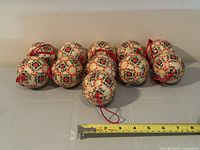 Group shot of all 11 floral ornaments with measuring tape for scale