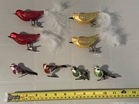 Group shot of all eight bird ornaments next to ruler for scale