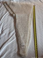 Full view of folded shawl with tape measure showing length