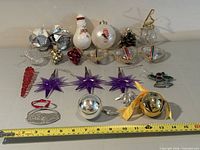 Full group of 20 assorted ornaments on table with measuring tape