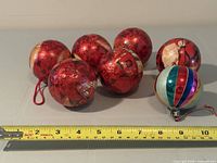 Group of seven ornaments with tape for scale