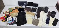 Overview showing gloves, handbags, clutches and scarf assortment on table