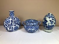 Group shot of vase, handled pot, and egg ornament with stand