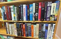 Full view of two shelves filled with assorted hardcover books