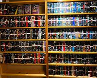 Full view of multiple wooden shelves filled with VHS tapes