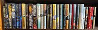 Shelf view of entire row of 25 John Grisham hardcover novels