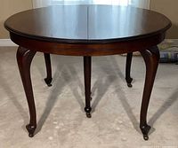 Round mahogany dining table no leaves, cabriole legs visible