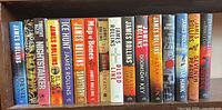Full shelf view of all 16 James Rollins hardcovers