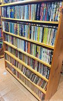 Full wooden bookcase packed with paperback books on six shelves