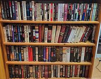 Full bookshelf showing three shelves packed with hardcovers