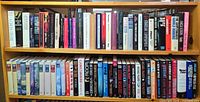 Two full shelves of assorted hardcover novels with dust jackets