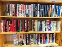 Three shelves filled edge-to-edge with hardcover novels.