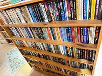 Full bookcase showing three packed shelves of mass-market paperbacks