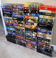 Four tall stacks of mass market paperbacks showing spines