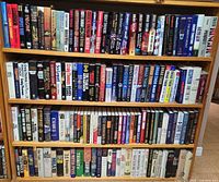 Full bookshelf showing four shelves of thriller, military and mystery books