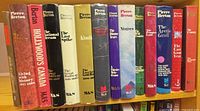 Spine view of 14 Pierre Berton hardcovers on shelf