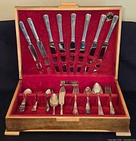Open wooden case showing full set of flatware