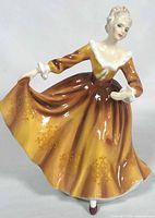 Front view of Royal Doulton “Kirsty” figurine in brown/gold gown
