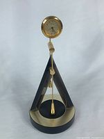 Front view of Seiko quartz magnetic double pendulum desk clock showing overall form and dial
