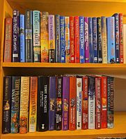Full view of two shelves showing all Terry Pratchett hardcovers
