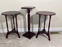 Front view of all three dark brown tables standing together