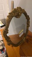 Front view of ornate gold framed mirror on table