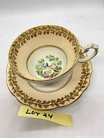 Teacup seated on saucer showing interior decal and gold border