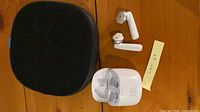 Earbuds, charging case open, soft pouch overview