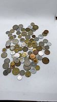 Full spread of assorted world coins on white background