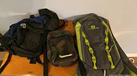 Three bags laid out: large Outbound backpack, Outbound sling pack, Nike SB pouch