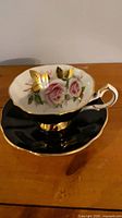 Teacup resting on saucer showing floral interior and gold trim