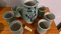 Top view of pitcher surrounded by six cups