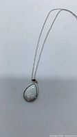 Front view of teardrop opal pendant on chain